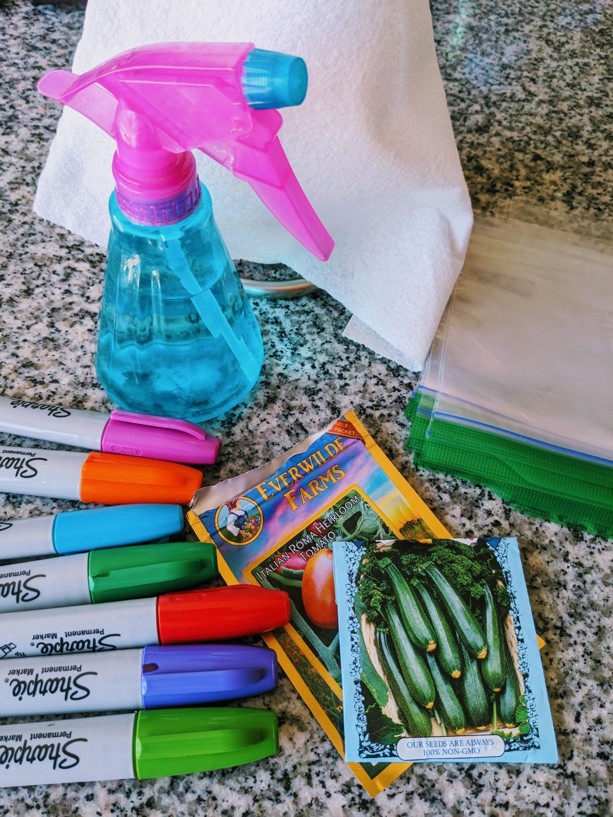 Spray bottle, baggies, paper towel, seeds, and markers