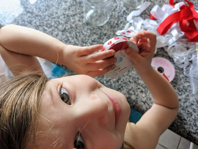 Little 5yo Girl Choosing Red Heart Ribbon for a Valentine Craft