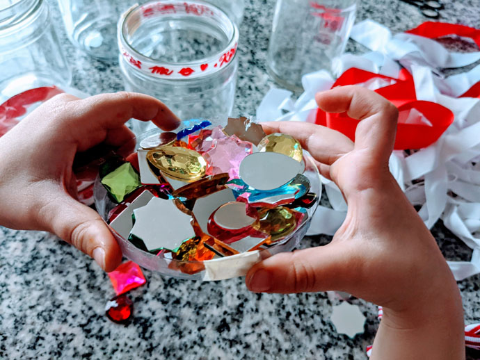 Little Girl's Hands Holding Rhinestones with Ribbons in the Background