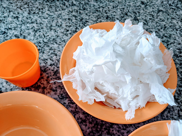 Homemade Recycled Paper Without Blender - Orange Bowl with Torn Tissues and an Orange Cup of Water