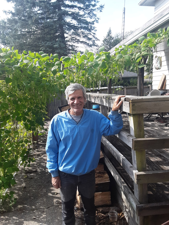 Paul DeRose the Pool Gardener under the green beans by his deck, Photo Courtesy of ThePoolGardener.com