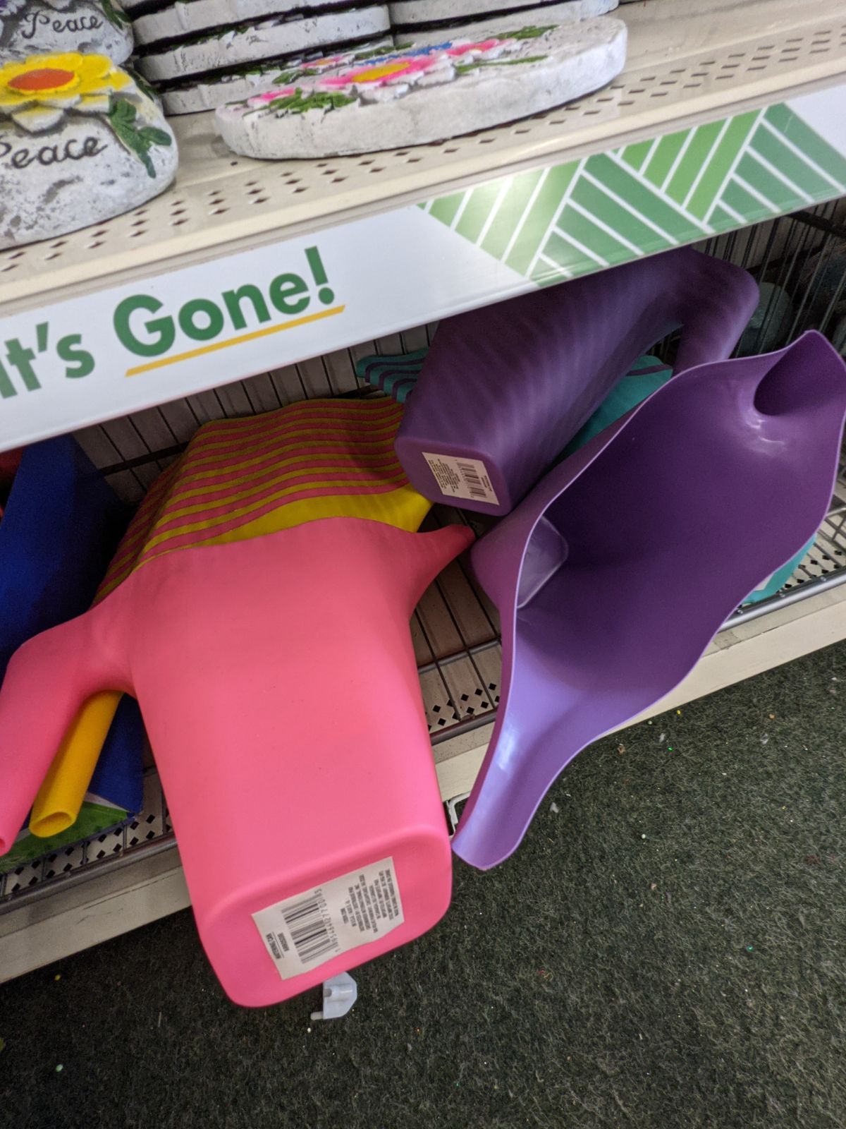 Pink purple and yellow watering cans for sale at the dollar store