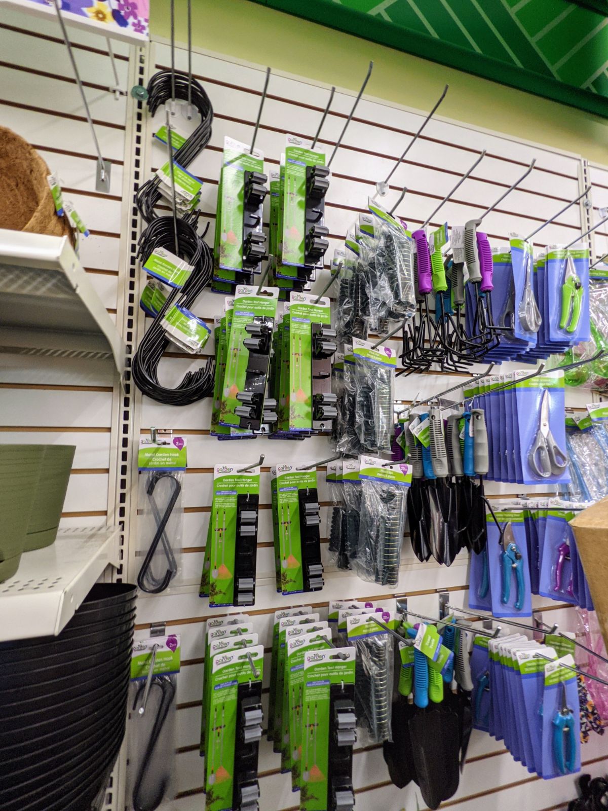 Dollar store gardening tools section with hand spades, hooks, and more