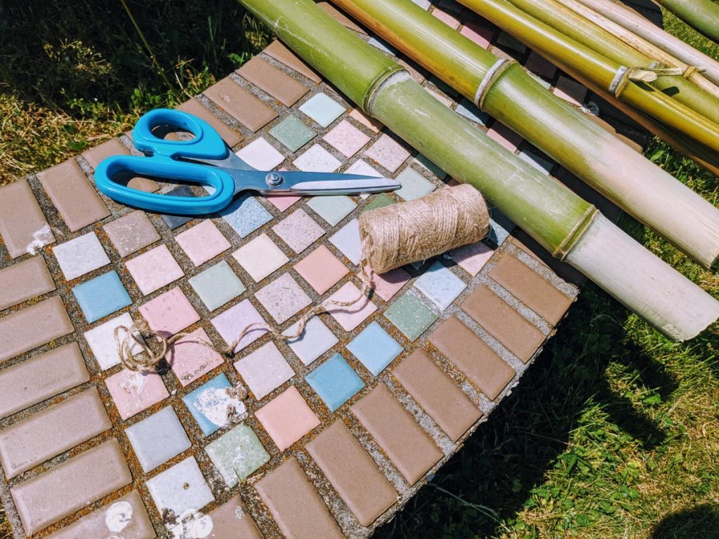 Green Bean Teepee supplies - scissors, bamboo and twine on a mosaic tile bench
