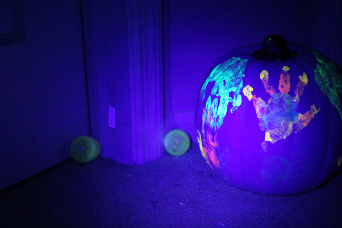 Glowing Halloween Handprints on a White Faux Pumpkin Preschool Halloween Craft