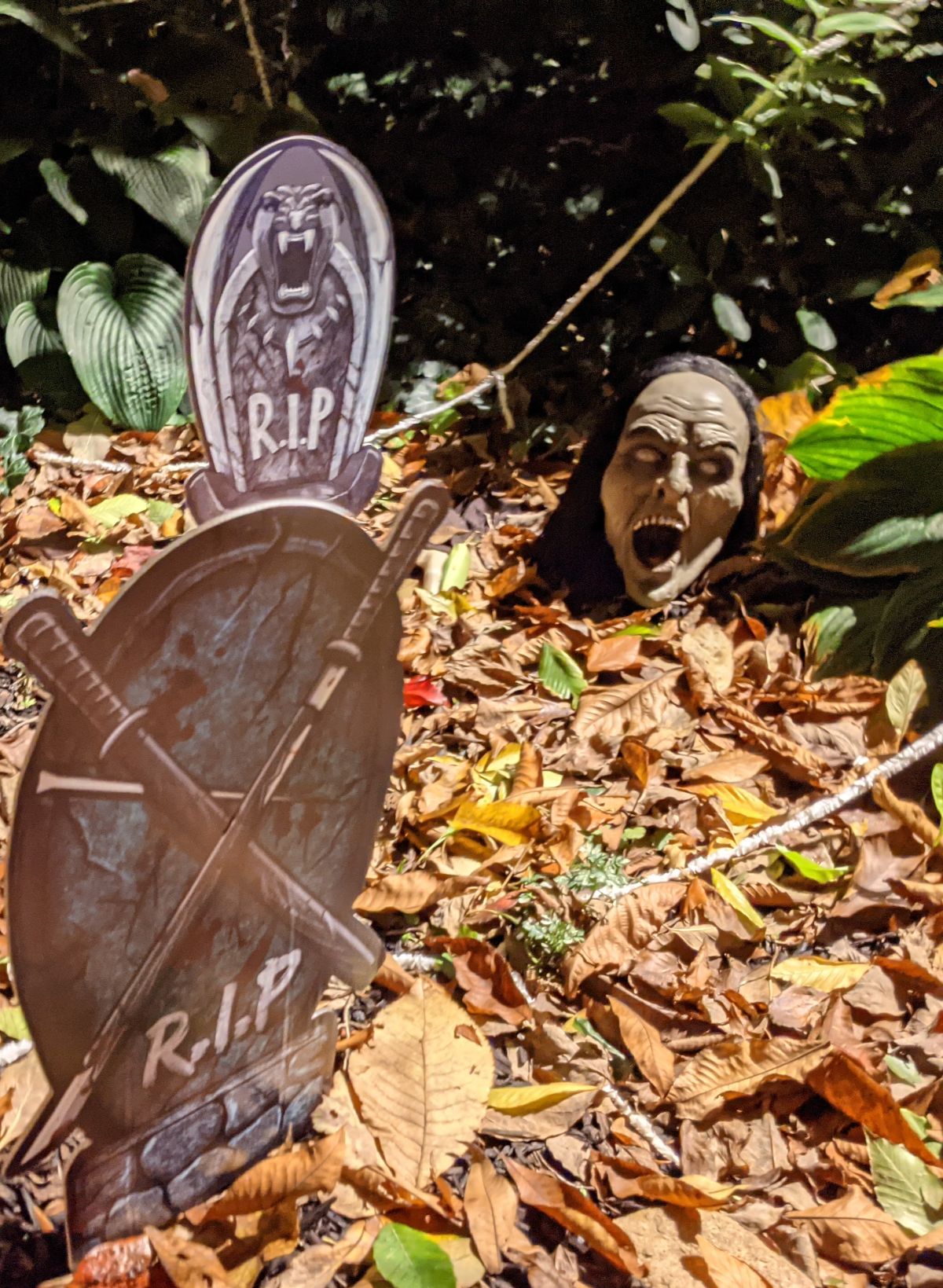 Creepy zombie head and tombstones in Halloween garden