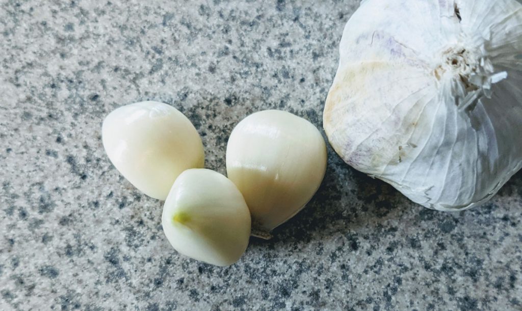 Garlic Companion Planting - Garlic bulb and cloves unwrapped