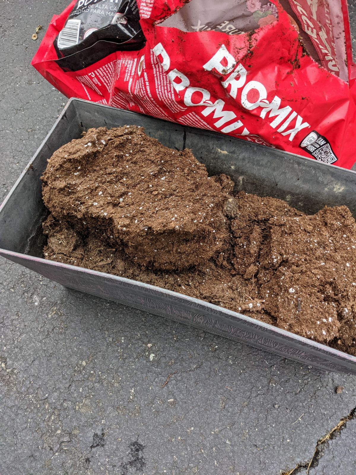 Pro-Mix moisture soil compressed and poured into a planter in the driveway