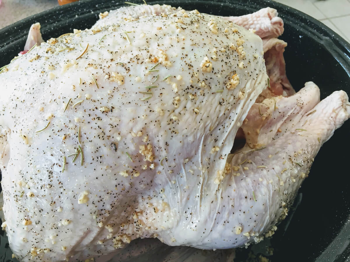 Seasoning Raw Poultry Turkey in a Pan with some herbs