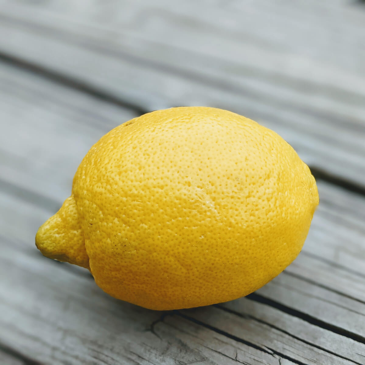 Fresh, delicious, yellow lemon on a wooden deck