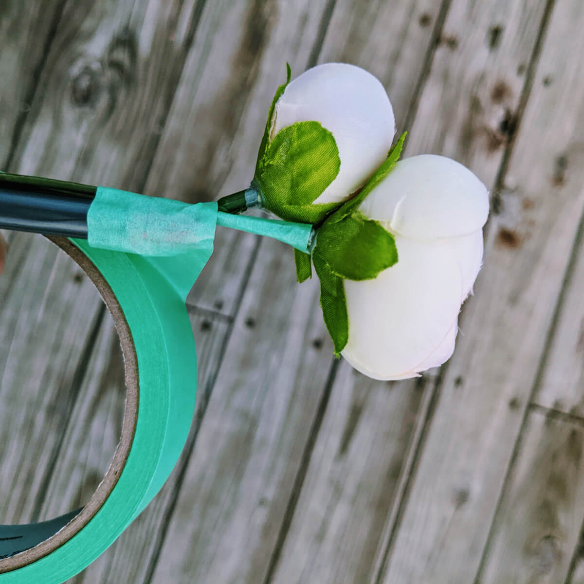 Taping a flower pen with green masking tape