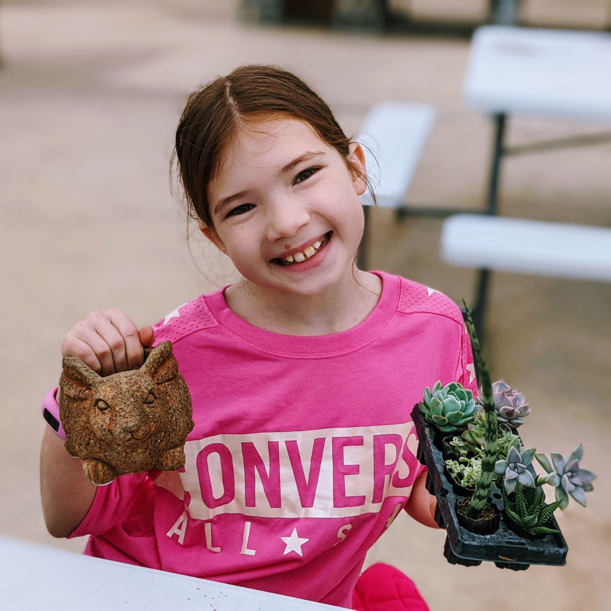 Girl holding succulents and bunny flower pot