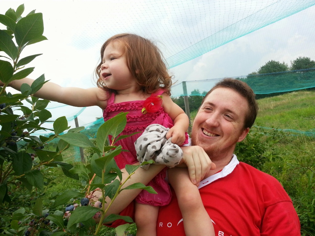 Uncle and niece picking blueberries