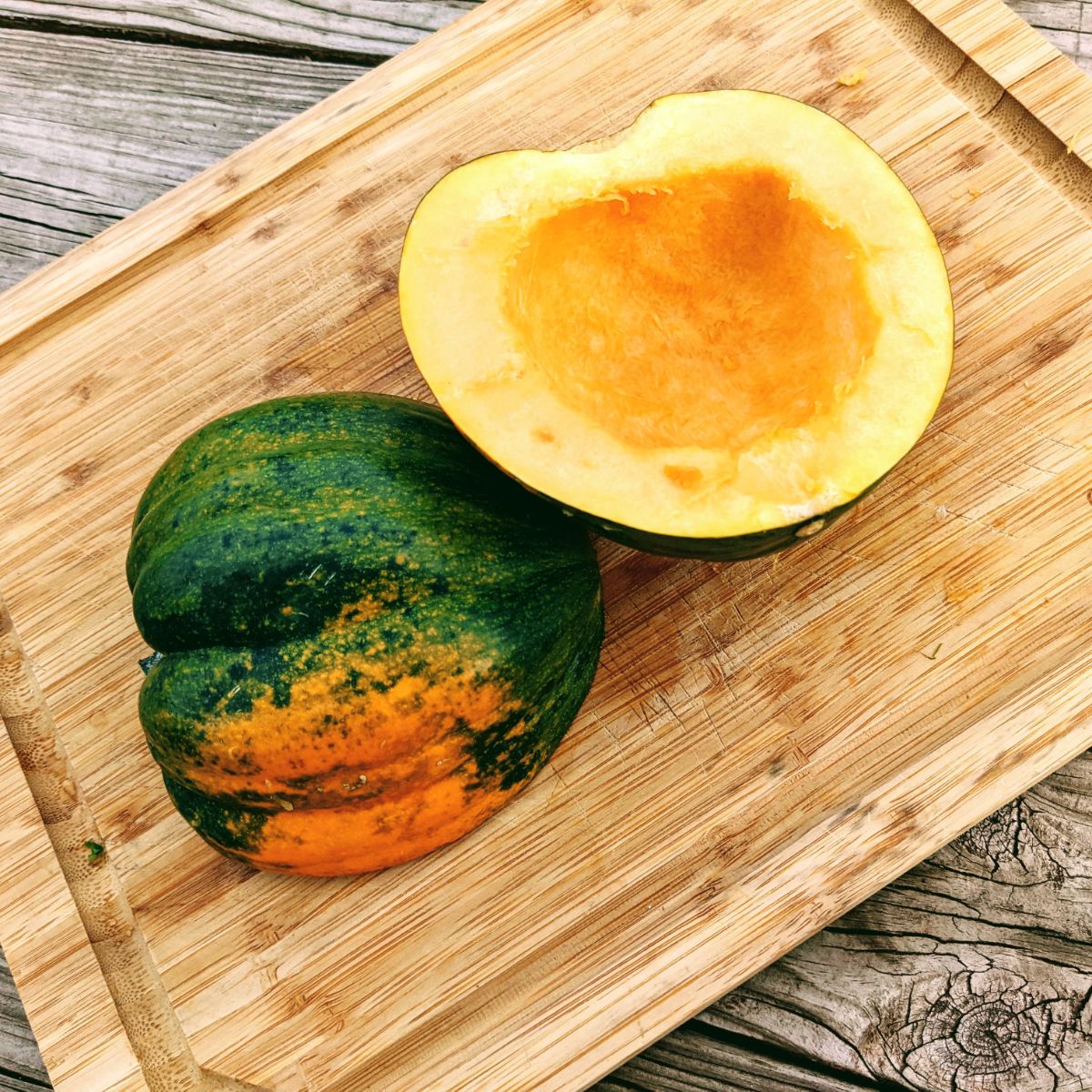 Halved acorn squash cut open on a cutting board