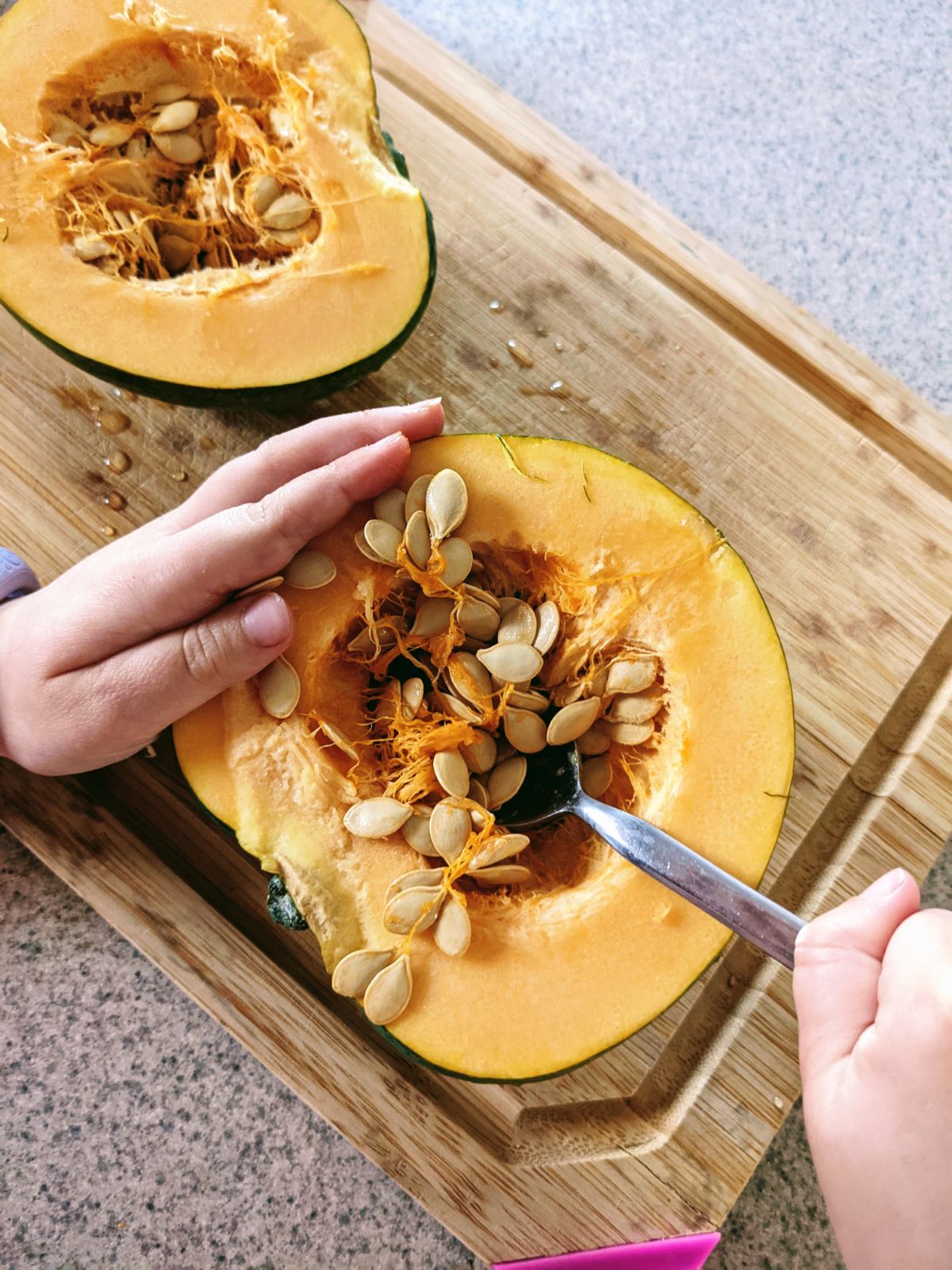 Scoop squash seeds with a spoon