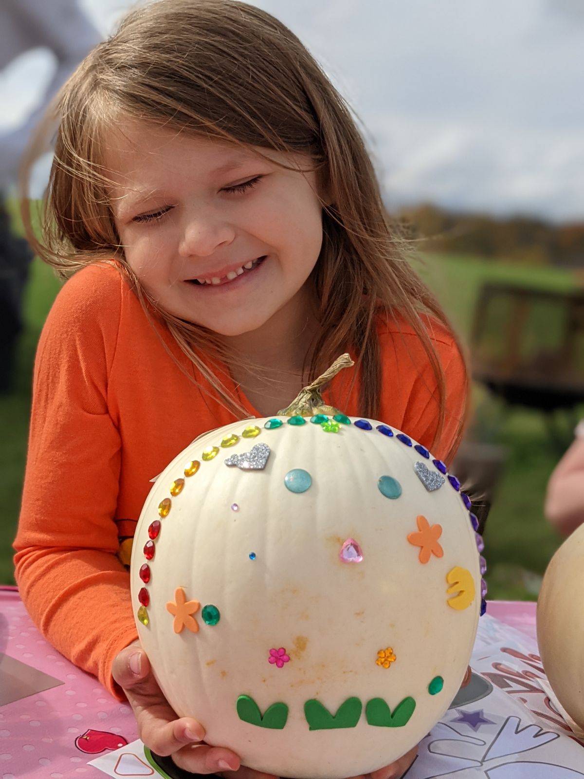 Smiling birthday girl with decorated white pumpkin