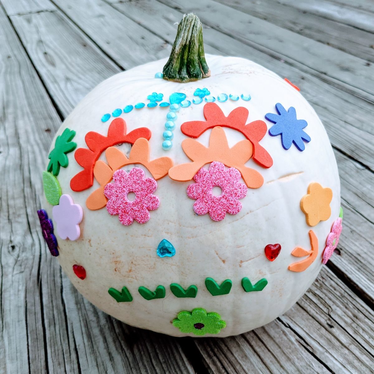 Sugar Skull Pumpkin - white pumpkin decorated with flower stickers and sticky rhinestones