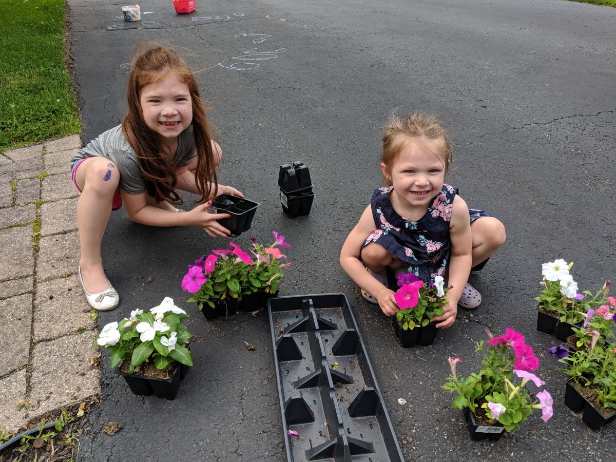 Two sisters planting annual flowers