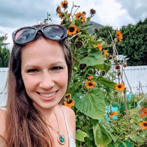 Kate Van Druff, owner of BunnysGarden.com, standing with branching sunflowers