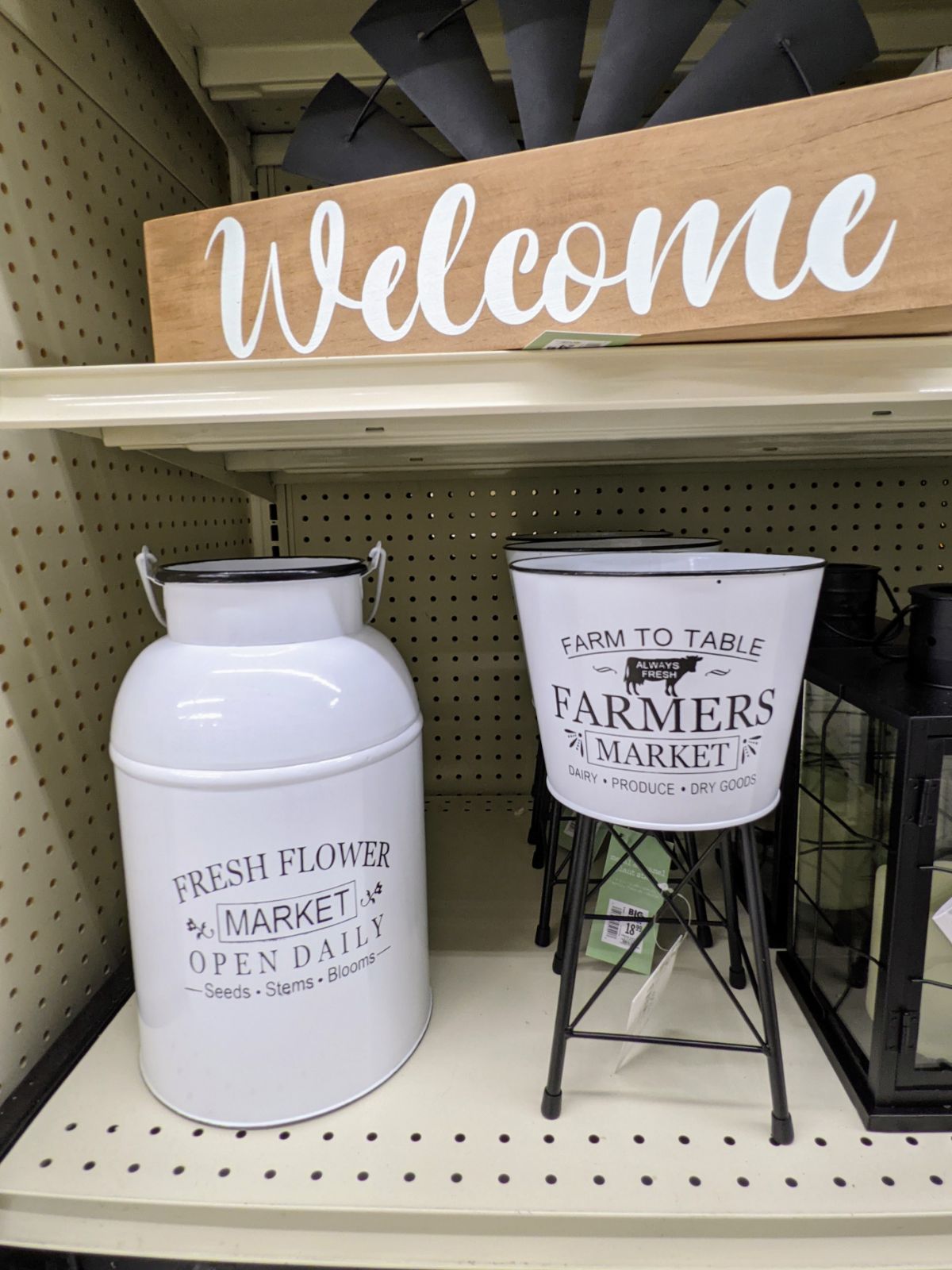 Farmhouse décor, including a standing Farmers planter and milk jug under a welcome sign at Big Lots