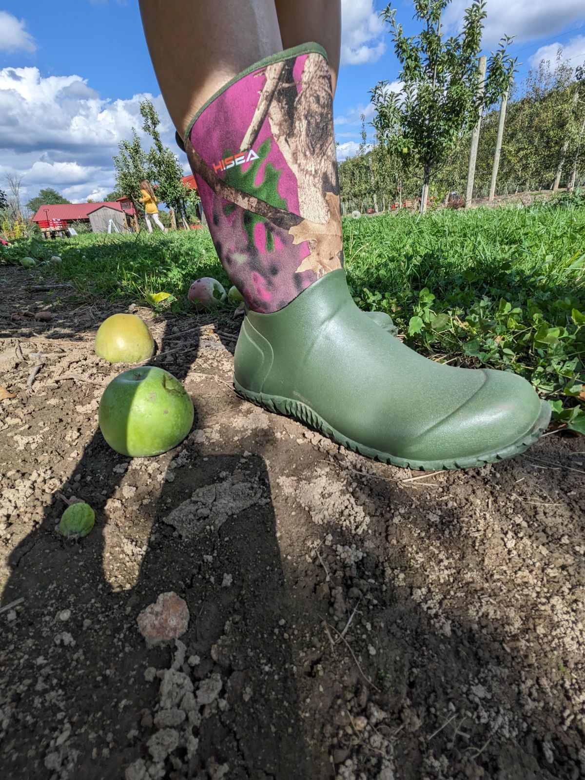Apple picking in boots by HISEA, standing on soil with fallen apples