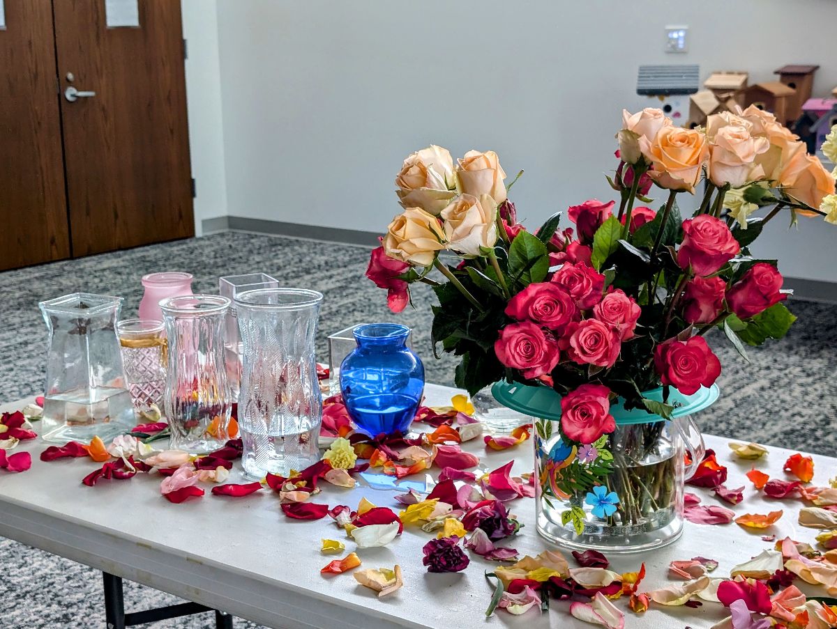 Bouquet building station with vases, flowers, rose petals set up for a party or teambuilder